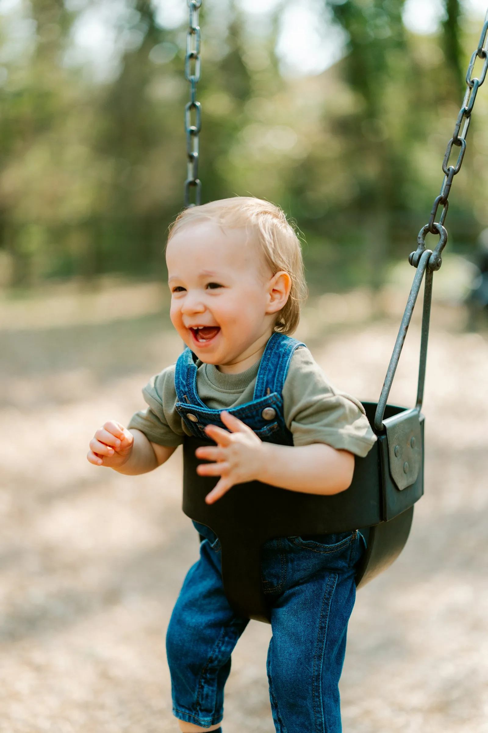 A laughing baby enjoying a swing outdoors