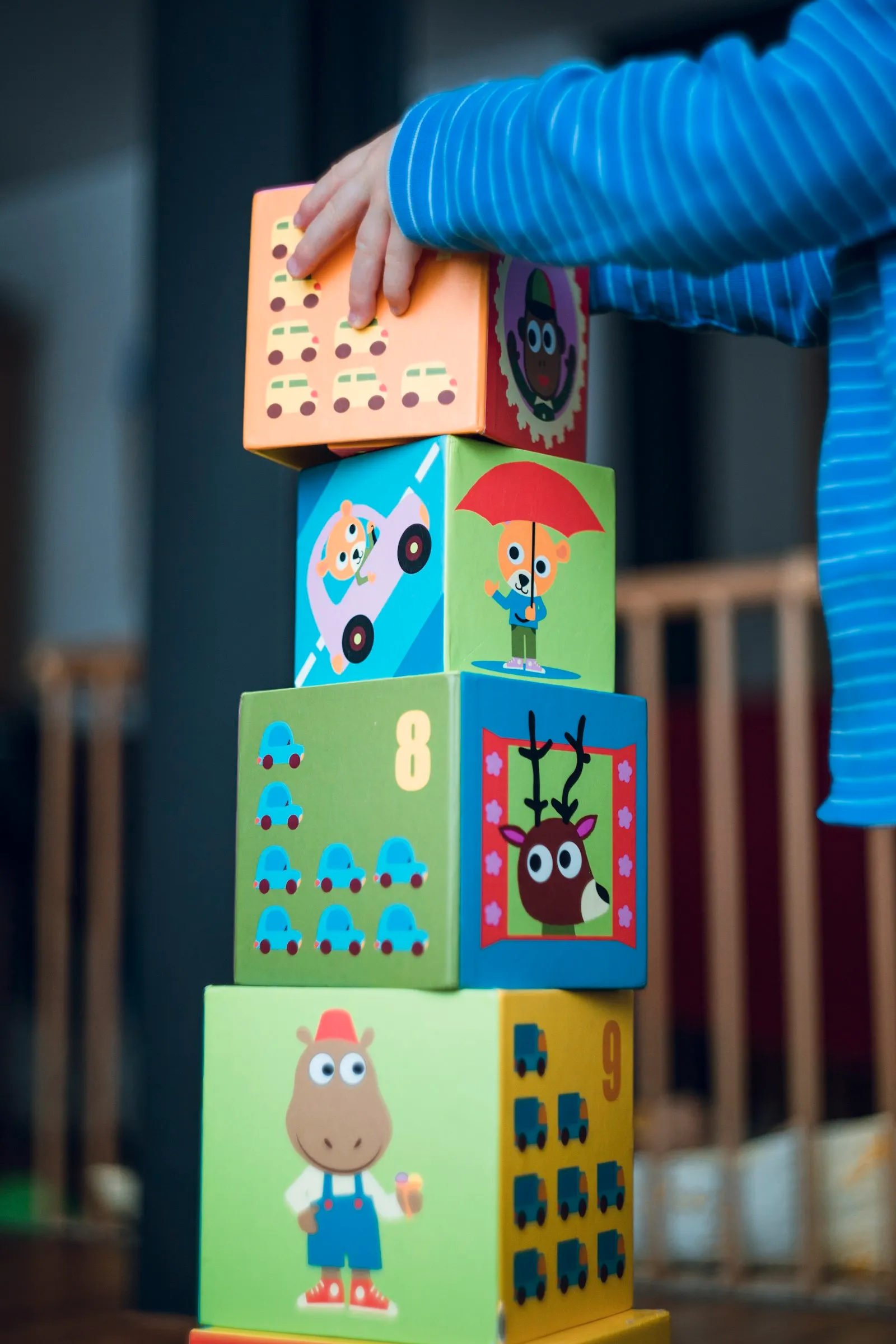 A child stacking colourful picture blocks