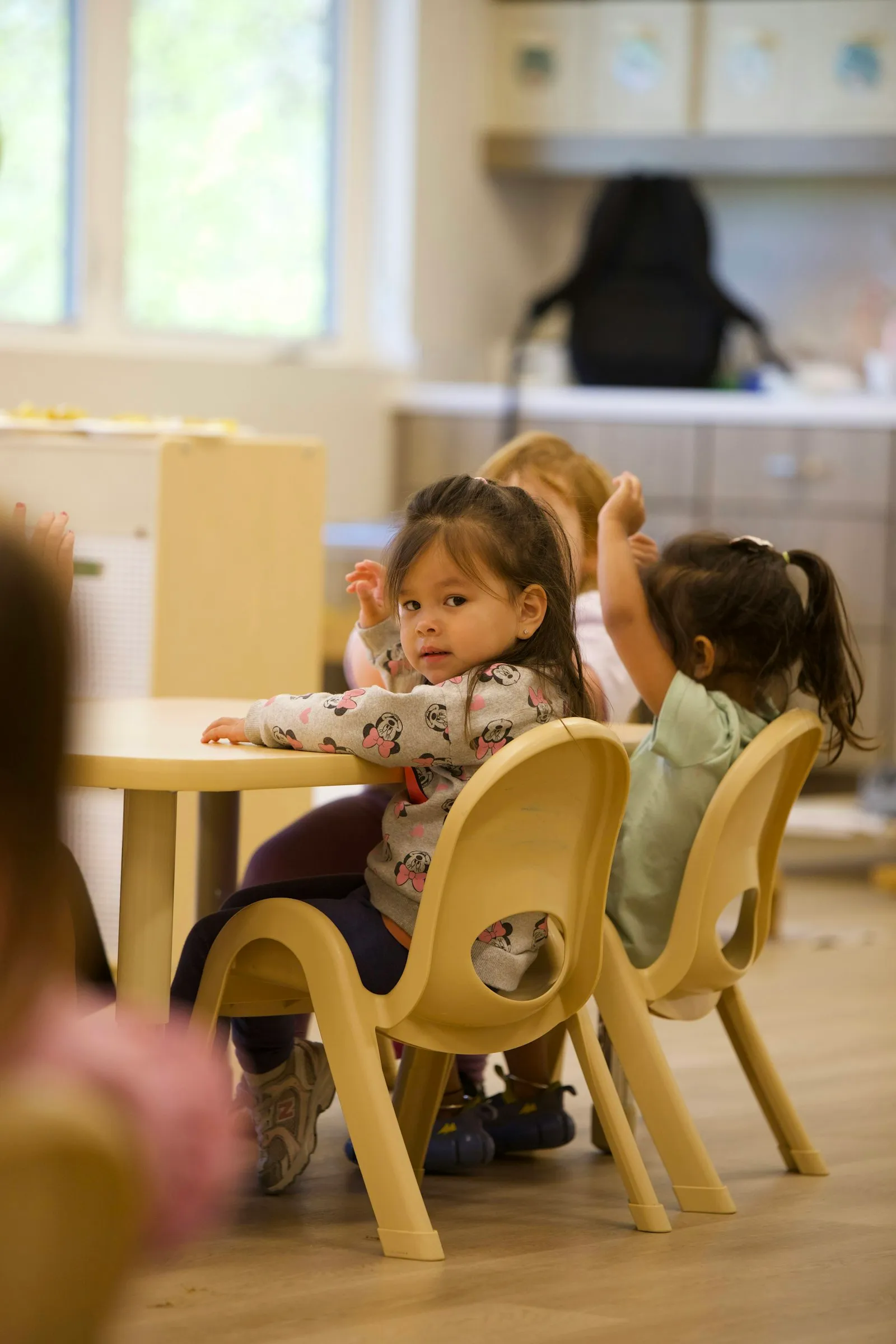Young children sitting together at a small classroom table